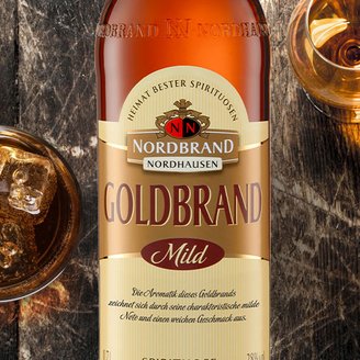 Das Bild zeigt den NN Weinbrand auf dunklem Holz.