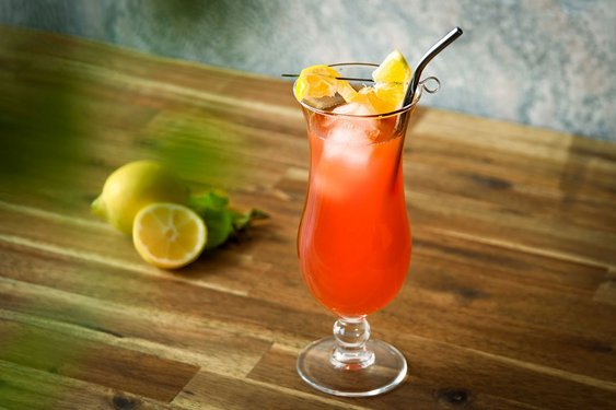 Das Bild zeigt einen roten Cocktail im Longdrinkglas mit Strohhalm