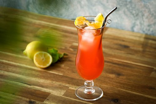 Das Bild zeigt einen roten Cocktail im Longdrinkglas mit Strohhalm 